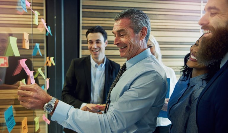 Smiling businesspeople with sticky notes